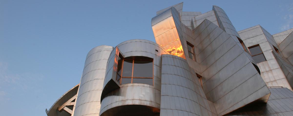picture of Weisman museum against blue sky with setting sun reflected in the metal panels